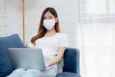 年轻的亚洲业务女人脸面具工作首页移动PC电脑在线互联网生活房间女孩医疗面具检疫流感大流行科维德保持首页正常的