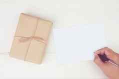 手男人。写作信空白问候卡礼物盒子卡夫纸木表格现在包明信片模型前视图平躺复制空间假期概念