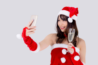 美丽的肖像年轻的亚洲女人圣诞老人持有玻璃香槟自拍电话聚会，派对庆祝圣诞节假期孤立的白色背景圣诞节一年概念
