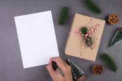 圣诞节假期礼物盒子装饰问候卡一年圣诞节周年纪念日礼物手写作明信片水泥地板上背景前视图平躺复制空间