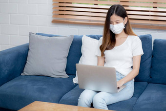 年轻的亚洲业务女人脸面具工作首页移动PC电脑在线互联网生活房间女孩医疗面具检疫流感大流行科维德保持首页正常的