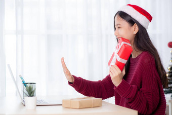 年轻的亚洲女人自拍视频调用在线朋友显示红色的礼物盒子圣诞节一天相机首页社会距离正常的女视频会议沟通假期