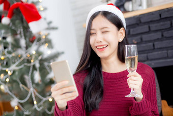 年轻的亚洲女人自拍<strong>视频</strong>调用在线朋友显示玻璃圣诞节一天电话首页社会距离正常的女<strong>视频</strong>会议沟通<strong>假期</strong>概念