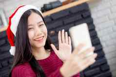 年轻的亚洲女人自拍视频调用在线朋友圣诞节一天电话首页社会距离正常的女视频会议智能手机沟通假期概念