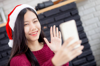 年轻的亚洲女人自拍<strong>视频</strong>调用在线朋友圣诞节一天电话首页社会距离正常的女<strong>视频</strong>会议智能手机沟通<strong>假期</strong>概念