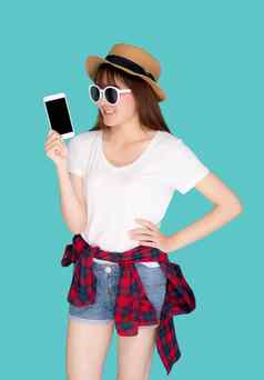 美丽的年轻的亚洲女人显示聪明的移动电话展示旅行夏天旅行假期孤立的蓝色的背景亚洲女孩持有智能手机假期概念