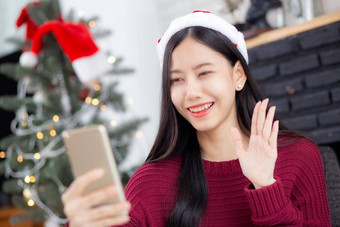 年轻的亚洲女人自拍<strong>视频</strong>调用在线朋友圣诞节一天电话首页社会距离正常的女<strong>视频</strong>会议智能手机沟通<strong>假期</strong>概念
