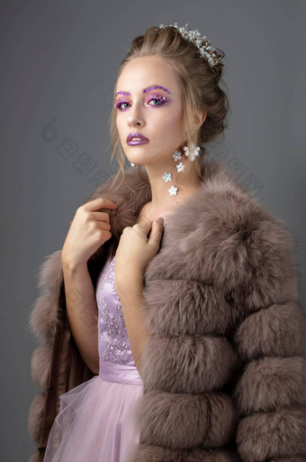 美丽的模型时尚化妆皮毛外套奢侈品冬天女孩灰色的背景