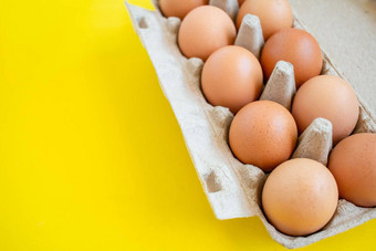 特写镜头棕色（的）鸡蛋纸盒子盒子完整的鸡蛋买了超市黄色的背景