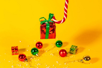 糖果狗棒棒糖持<strong>有礼</strong>物盒子圣诞节现在黄色的背景圣诞节糖果一年装饰