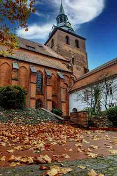 教堂米歇利斯小镇吕内堡秋天一天黄色的叶子前景