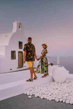 圣托里尼岛希腊年轻的夫妇奢侈品假期岛圣托里尼岛看日出蓝色的圆顶教堂白色村aio圣托里尼岛希腊日出