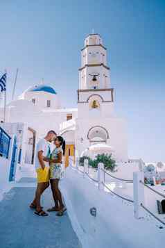 夫妇喝咖啡传统的村皮尔戈斯圣托里尼岛希腊年轻的夫妇奢侈品假期岛圣托里尼岛看日出蓝色的圆顶教堂白色村aio圣托里尼岛希腊