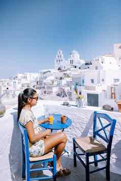 圣托里尼岛希腊年轻的女人奢侈品假期岛圣托里尼岛看日出蓝色的圆顶教堂白色村aio圣托里尼岛希腊日出但女人假期希腊