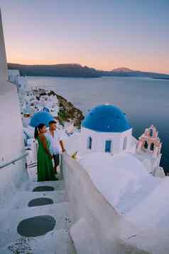 圣托里尼岛希腊年轻的夫妇奢侈品假期岛圣托里尼岛看日出蓝色的圆顶教堂白色村aio圣托里尼岛希腊日出但女人假期希腊
