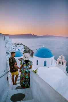 圣托里尼岛希腊年轻的夫妇奢侈品假期岛圣托里尼岛看日出蓝色的圆顶教堂白色村aio圣托里尼岛希腊日出但女人假期希腊