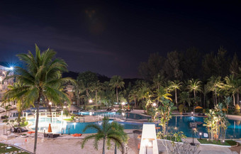 游泳池区域海滩酒店度假胜地晚上树光滑的蓝色的游泳池水反映灯长曝光
