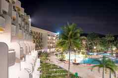 酒店阳台一边视图酒店度假胜地晚上游泳池明亮的灯反映蓝色的游泳池水长曝光