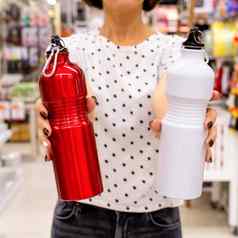 女人持有红色的白色不锈钢钢水瓶