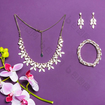 优雅的黄金项链手镯耳环钻石紫色的背景