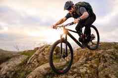 专业骑自行车的人骑自行车秋天岩石小道日落极端的体育运动复古骑自行车概念