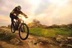 专业骑自行车的人骑自行车秋天岩石小道日落极端的体育运动复古骑自行车概念