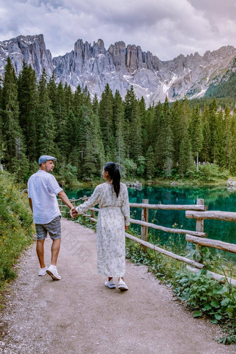 夫妇访问不停地蓝色的湖白云石山脉意大利卡莱扎湖泻湖卡莱扎卡雷尔西山拉蒂博尔扎诺省南提洛尔意大利景观湖卡莱扎卡雷尔西白云石山脉背景新星东方博尔扎诺意大利