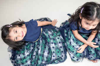 <strong>相同</strong>的双胞胎女孩姐妹摆姿势相机快乐双胞胎姐妹礼服相机微笑额视图白色背景