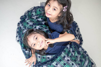 相同的双胞胎女孩姐妹摆姿势相机快乐双胞胎姐妹礼服相机微笑额视图白色背景