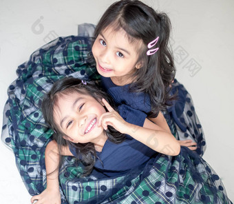 <strong>相同</strong>的双胞胎女孩姐妹摆姿势相机快乐双胞胎姐妹礼服相机微笑额视图白色背景