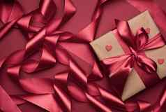 礼物盒子包装红色的纸卷丝绸丝带红色的背景节日背景