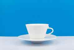 白色陶瓷咖啡杯飞碟白色表格蓝色的背景