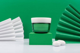 绿色奶油Jar绿色讲台上白色表格绿色装饰背景概念豪华的有机护肤品
