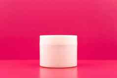 简单的生活白色Jar面具奶油乳香粉红色的表格粉红色的背景复制空间