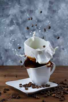 飞溅飞溅一块糖杯子咖啡杯子牛奶木背景
