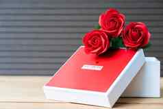 红色的玫瑰心形的盒子木背景