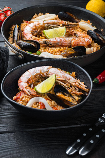 典型的西班牙语海鲜西班牙海鲜<strong>饭</strong>传统的锅黑色的碗黑色的木背景