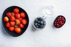 成熟的草莓蔓越莓蓝莓碗前视图白色背景