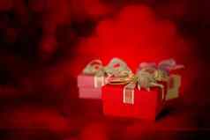 红色的礼物盒子丝带光模糊散景背景现在奢侈品爱周年纪念日发光的闪耀节日复制空间情人节一天圣诞节概念
