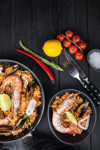 传统的西班牙语海鲜西班牙海鲜<strong>饭</strong>锅碗大米豌豆虾贻贝鱿鱼黑色的木木板前视图