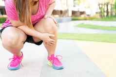 女高脂肪的跑步者运动员腿受伤疼痛手抓住痛苦的膝盖运行公园