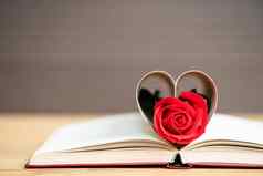 页面书弯曲的心形状红色的玫瑰