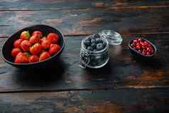 成熟的草莓蔓越莓蓝莓碗空间文本木背景