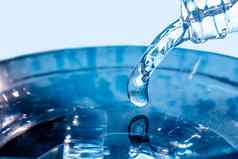流动流蓝色的水流蓝色的水倒脖子玻璃瓶冻水下降拍摄高速度慢滴液体空气泡沫冻液体溅