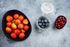 成熟的草莓蔓越莓蓝莓碗前视图变形背景