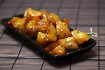 蜜饯甜蜜的土豆daigaku国际海事组织传统的日本食物深炸甜蜜的土豆涂层甜蜜的糖浆黑色的板炸甜蜜的土豆蜂蜜