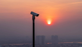 现代监测相机城市景观摩天大楼背景太阳成明亮的太阳设置