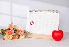 日历花心形状备忘录2月情人节一天桌子上提醒惊喜爱浪漫甜蜜的庆祝活动装饰前视图假期概念