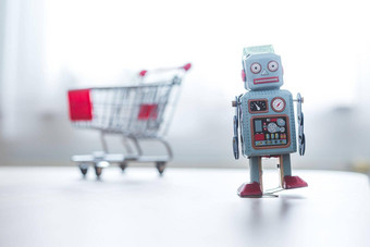 在线购物算法概念玩具机器人桌子上购物车模糊的背景