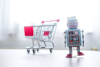 在线购物算法概念玩具机器人桌子上购物<strong>车模</strong>糊的背景
